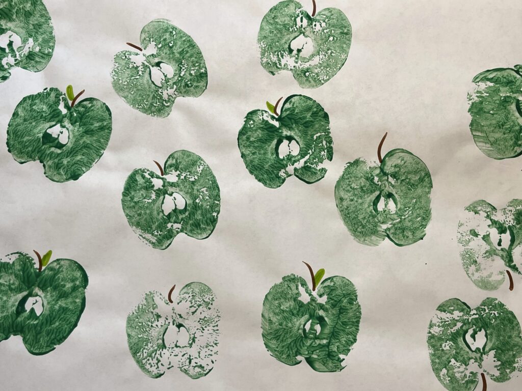 green apples made with apple stamps on white paper