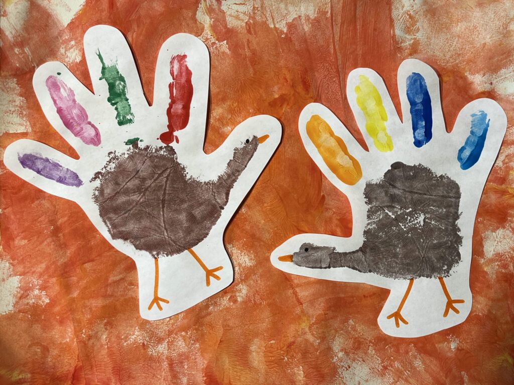 Handprint turkey project with orange fingerpainted background