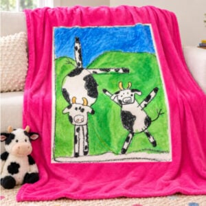 Pink Blanket with cow artwork on a couch