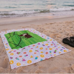 Summer fun beach towel with monkey artwork on the sand