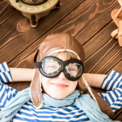 child in goggles with wooden plan